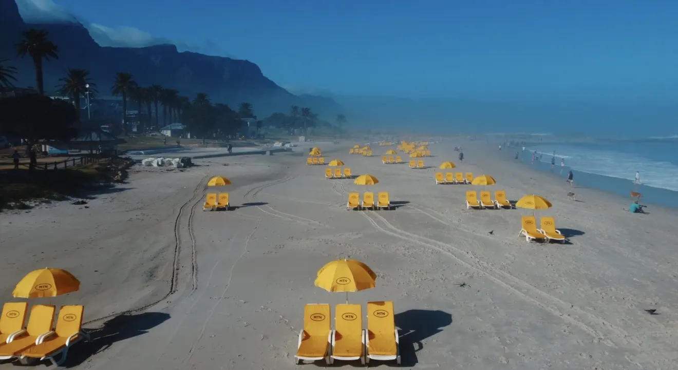 Branded beach umbrellas lining a South African beach